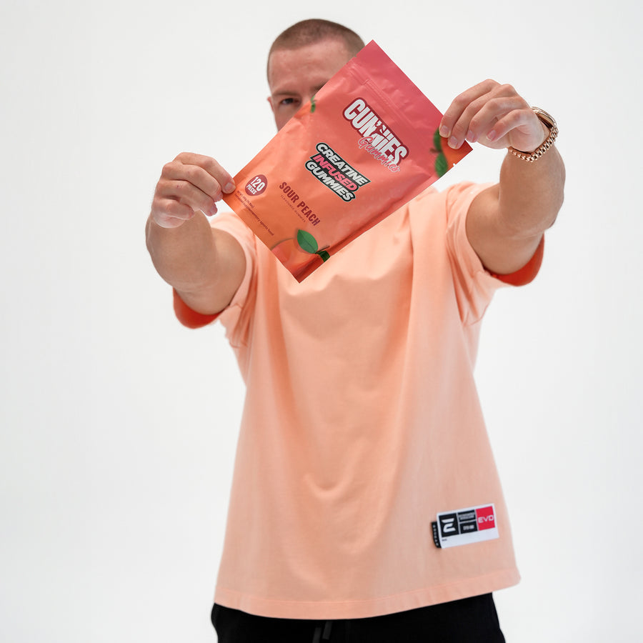 Man holding up a bag of Sour Peach Cunnies creatine gummies