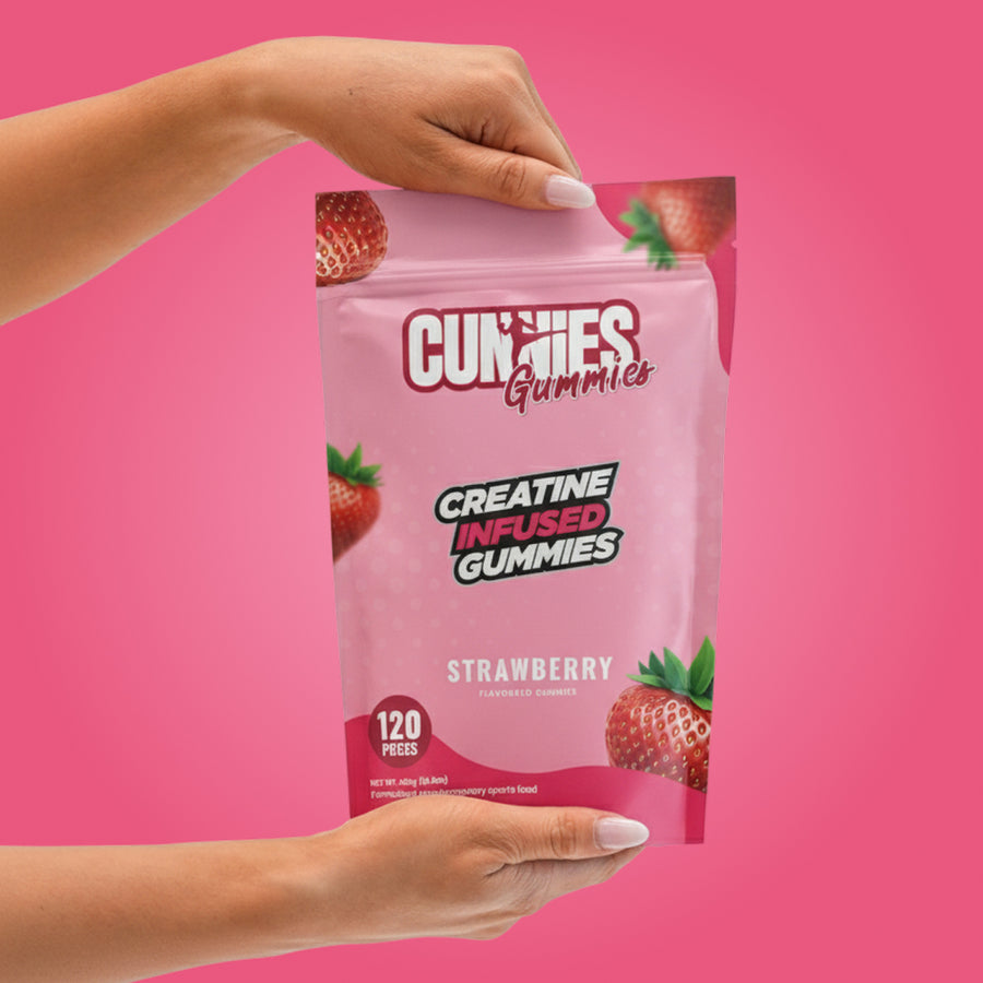 Hands holding a bag of Strawberry Cunnies creatine gummies on a pink background